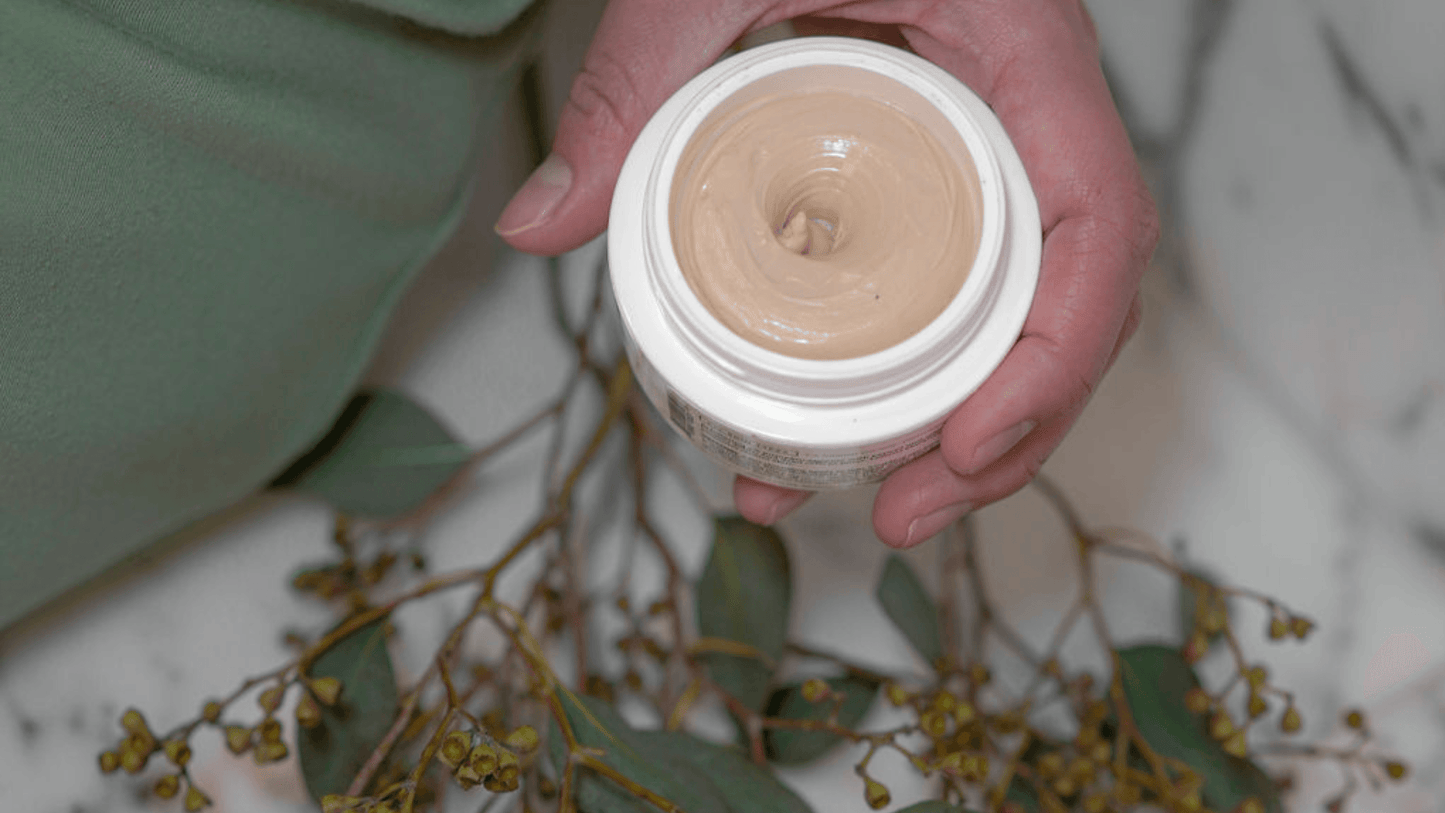 Holding an open mask jar with spring flowers on the counter