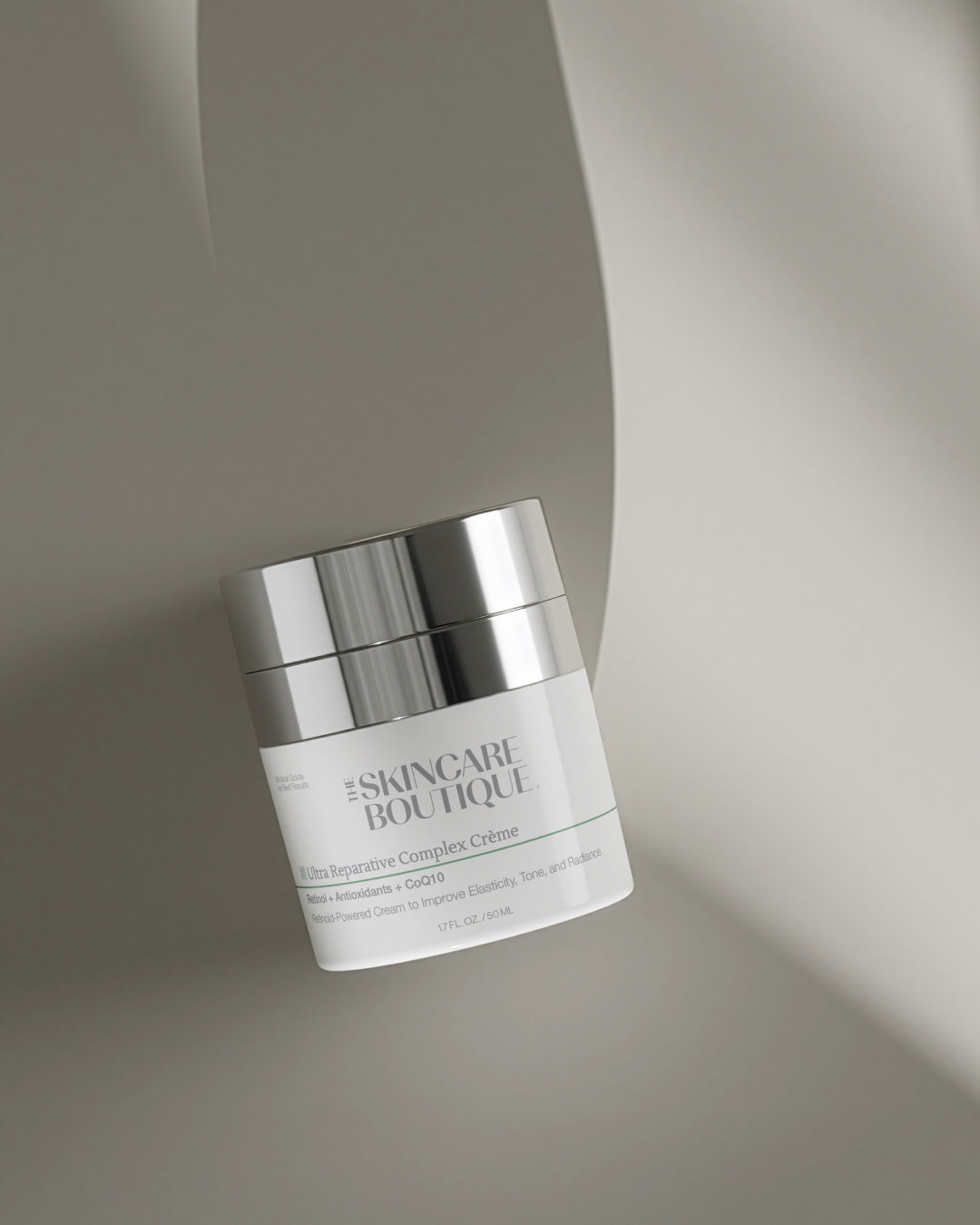 Skincare cream jar with silver lid on a neutral background