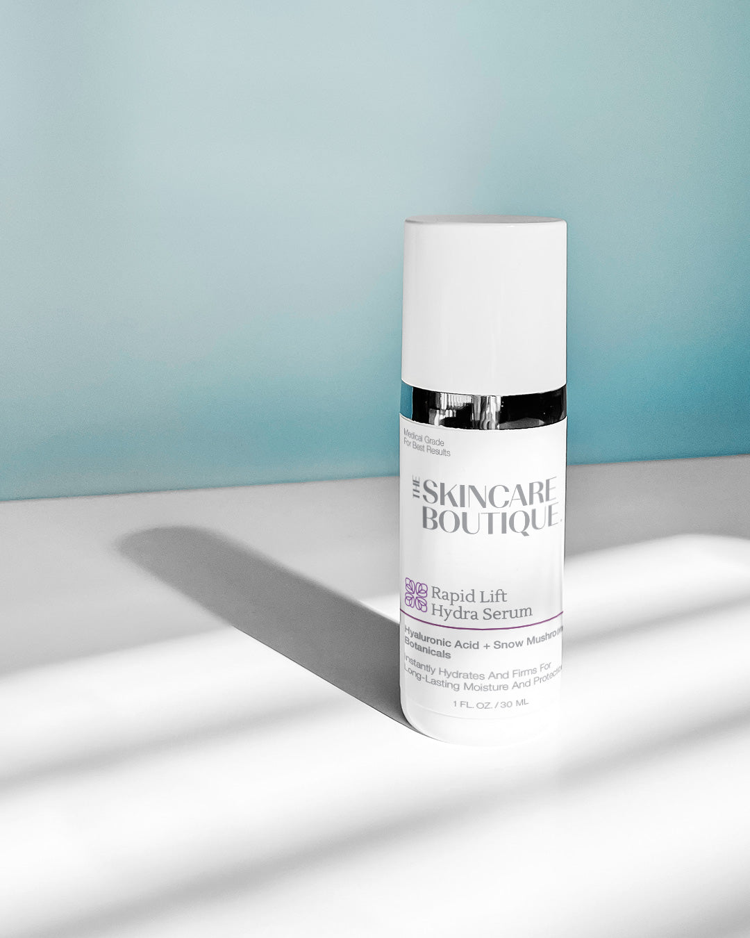 Skincare serum bottle labeled 'The Skincare Boutique' on a light surface with a blue gradient background