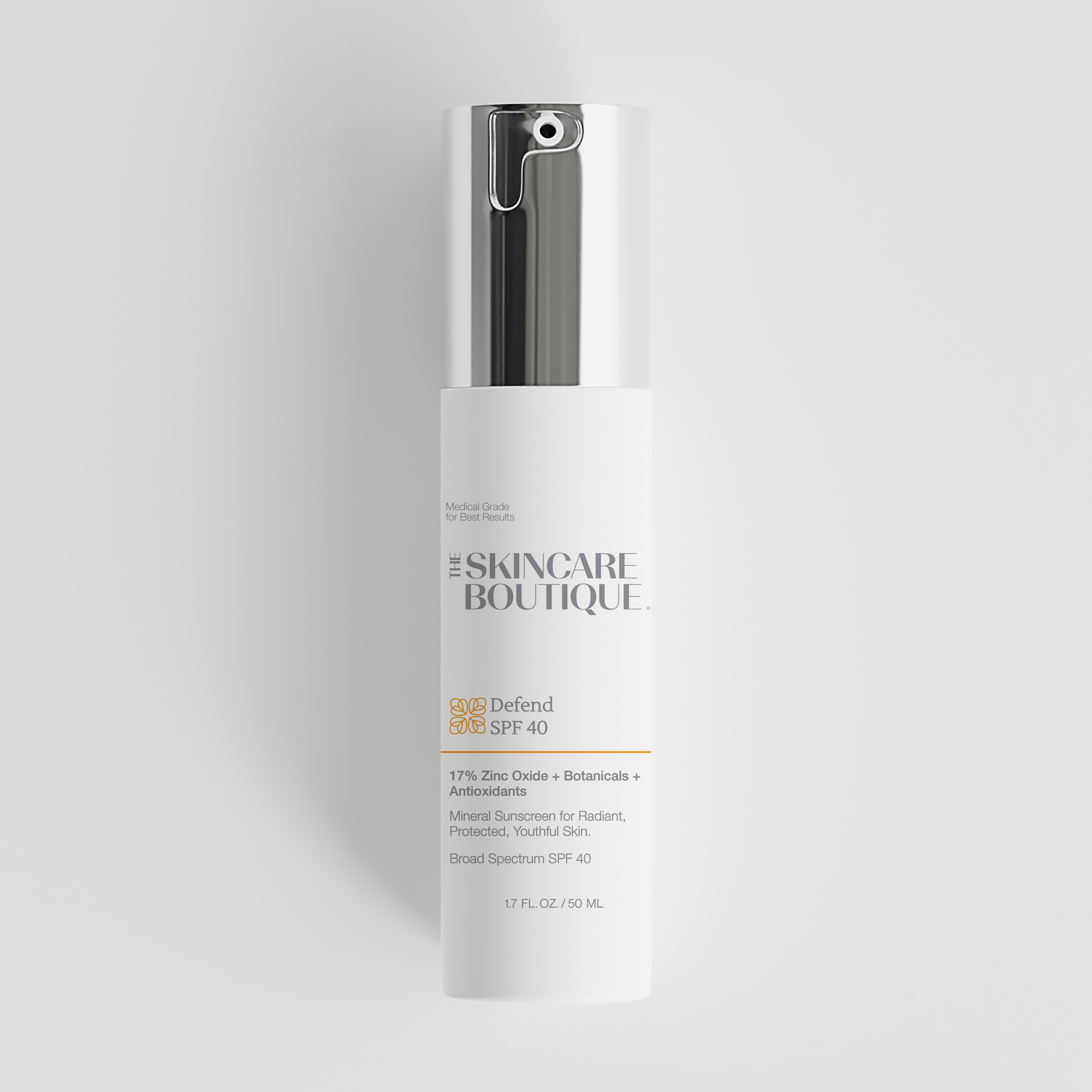 A white cylindrical sunscreen bottle with a metallic silver pump dispenser, featuring the brand name 'The Skincare Boutique' and product name 'Defend SPF 40' printed on the front, set against a light gray background.