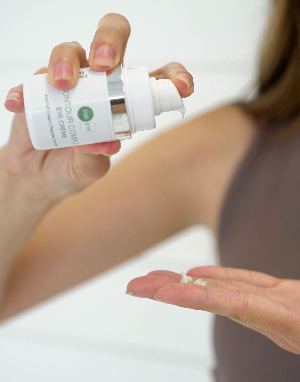 CONTOUR COMPLEX EYE CREME BEING PUMPED INTO HAND