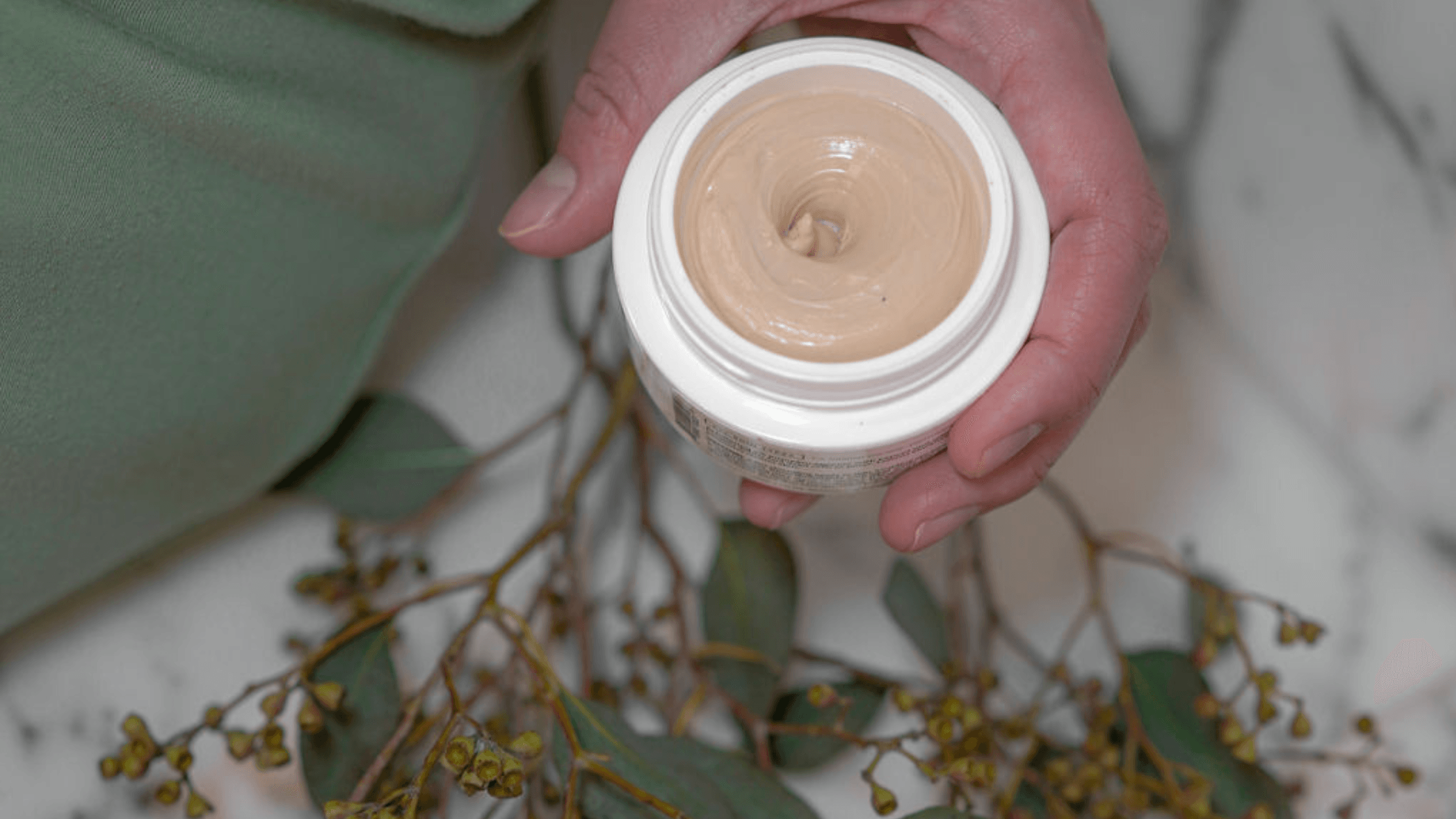 Holding an open mask jar with spring flowers on the counter