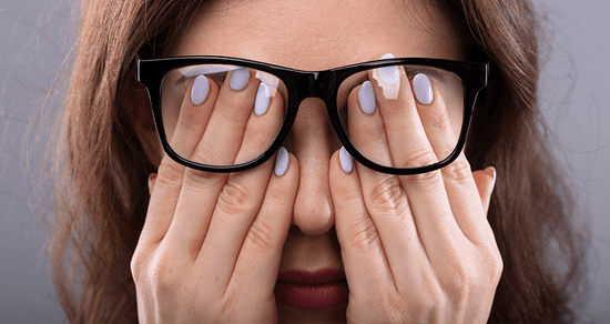 6 stress skin conditions. holding hands over eyes with glasses on