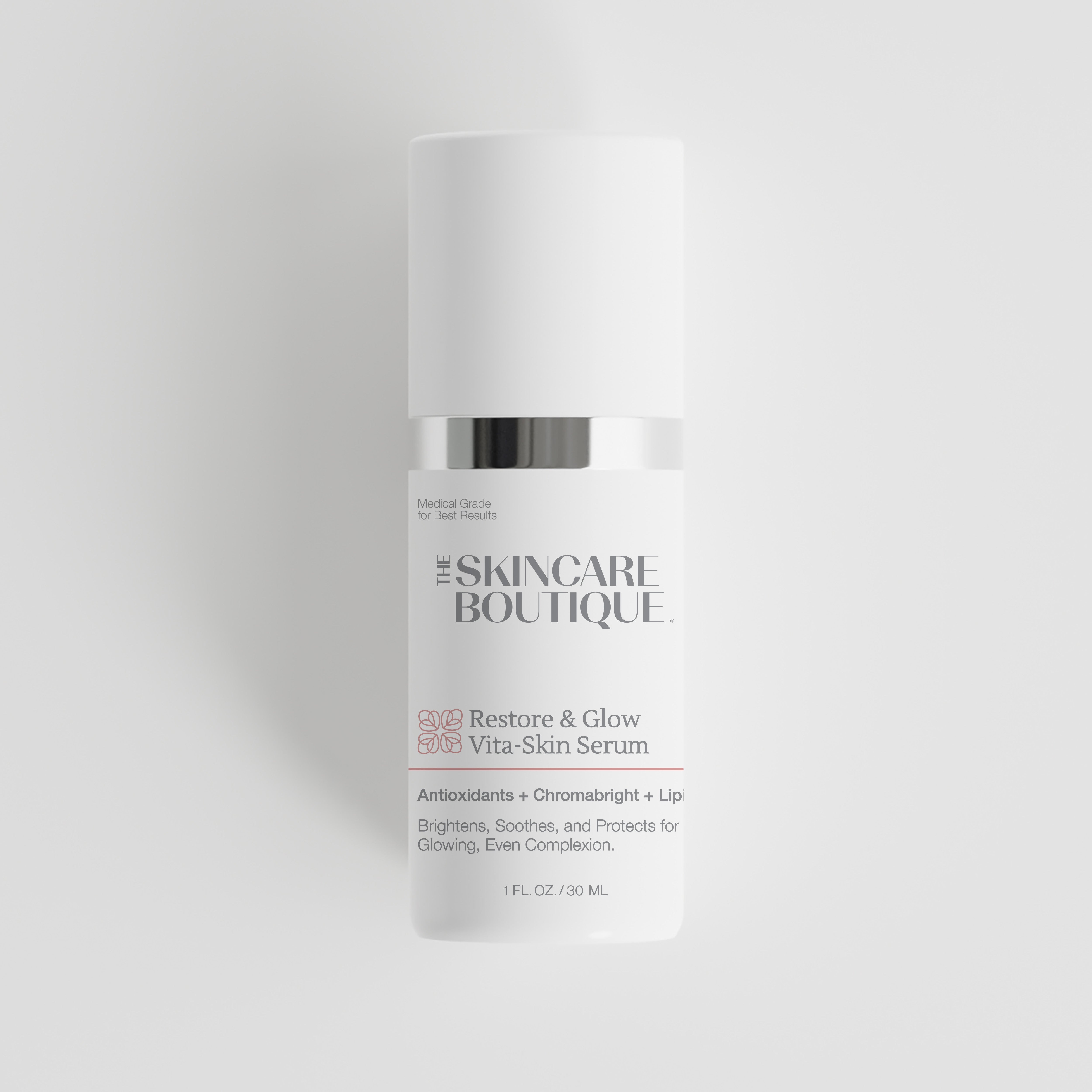 A white skincare serum bottle with a silver metallic band and black text reading 'The Skincare Boutique Restore & Glow Vita-Skin Serum' on a light gray background.