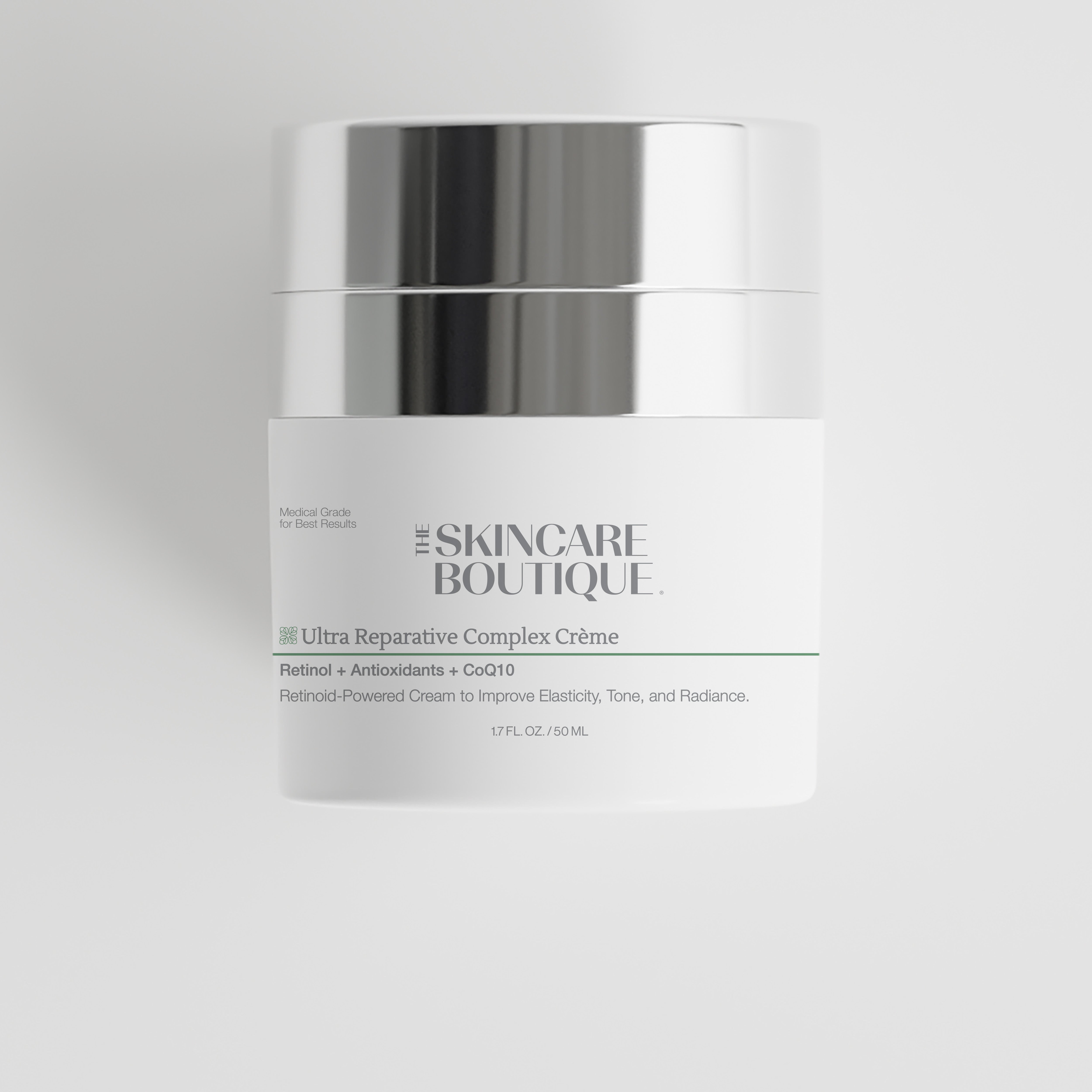 A white cosmetic cream jar with a shiny silver lid, labeled 'The Skincare Boutique Ultra Reparative Complex Crème' on a light gray background.