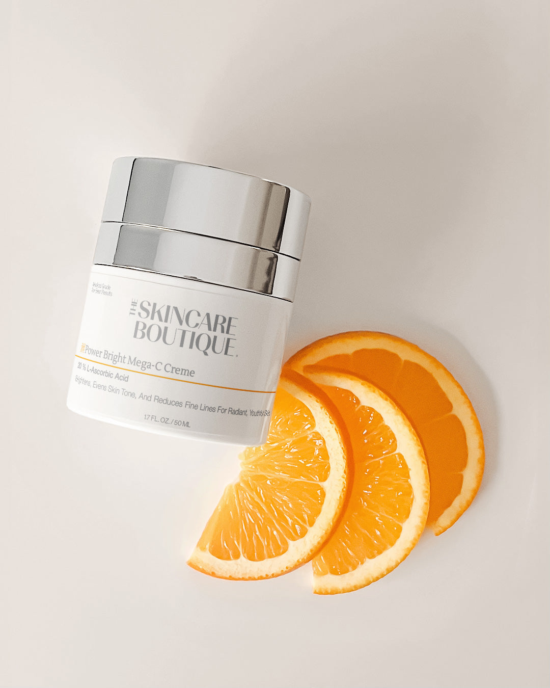 Skincare product jar with orange slices on a light background