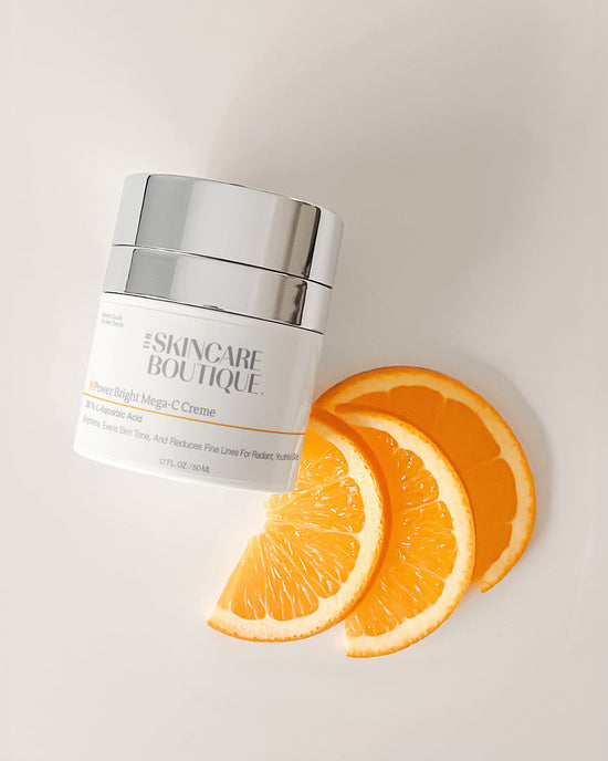 Skincare product jar with orange slices on a light background